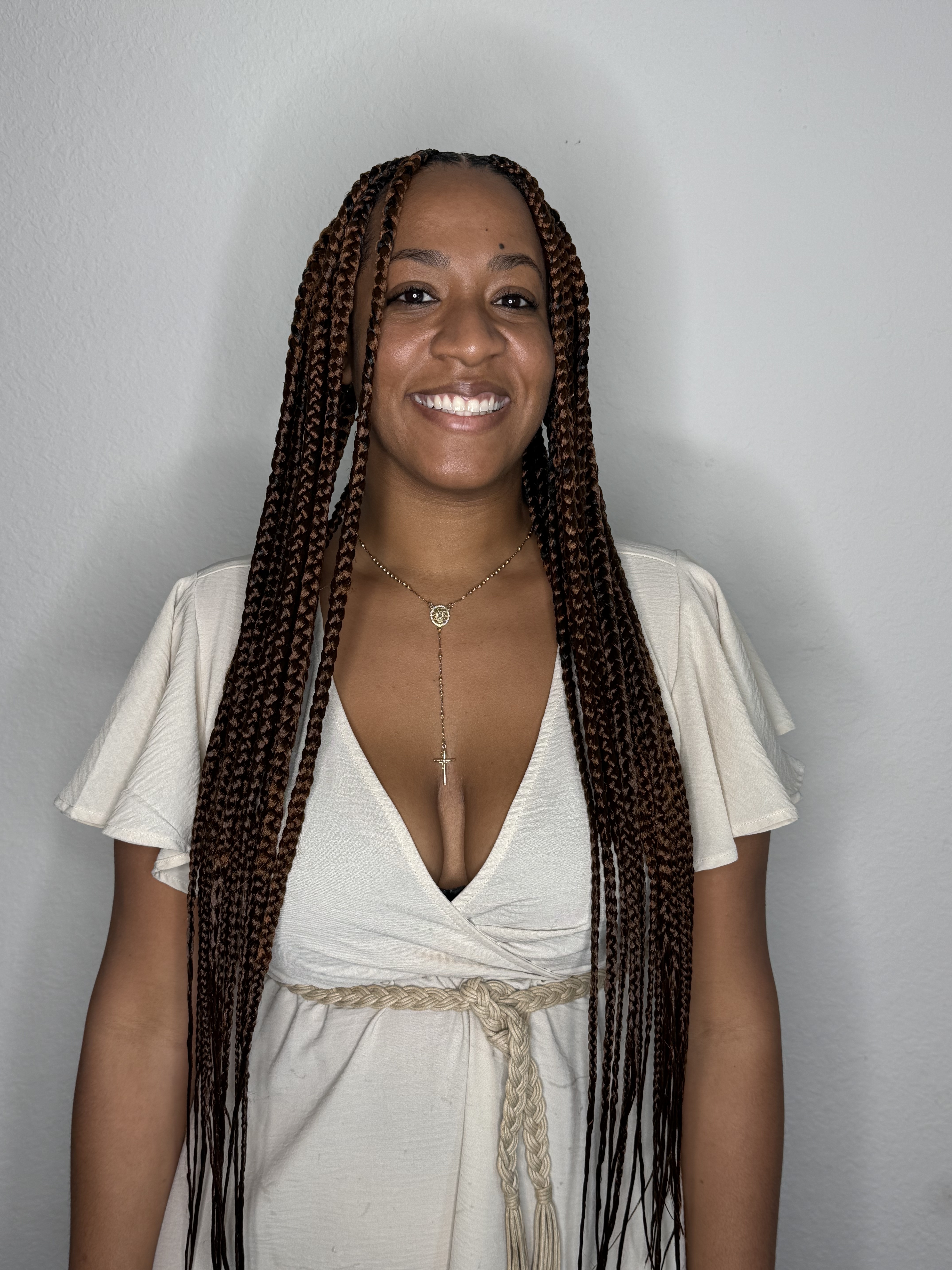 Smiling woman with long braids styled by Yulis near Cutler Bay