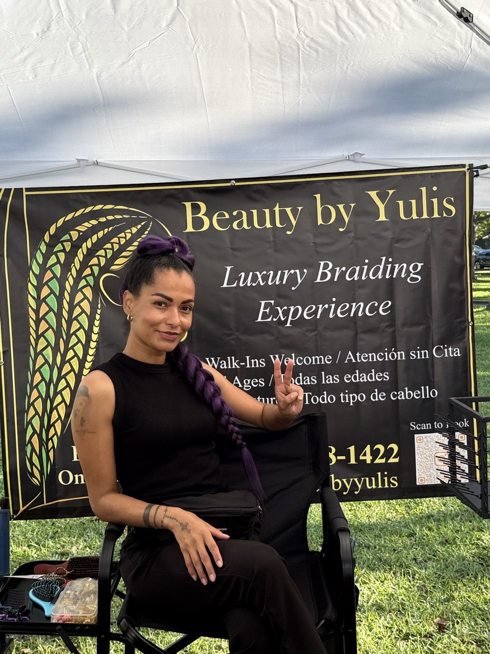 Yulis smiling in front of her business sign at Beauty By Yulis