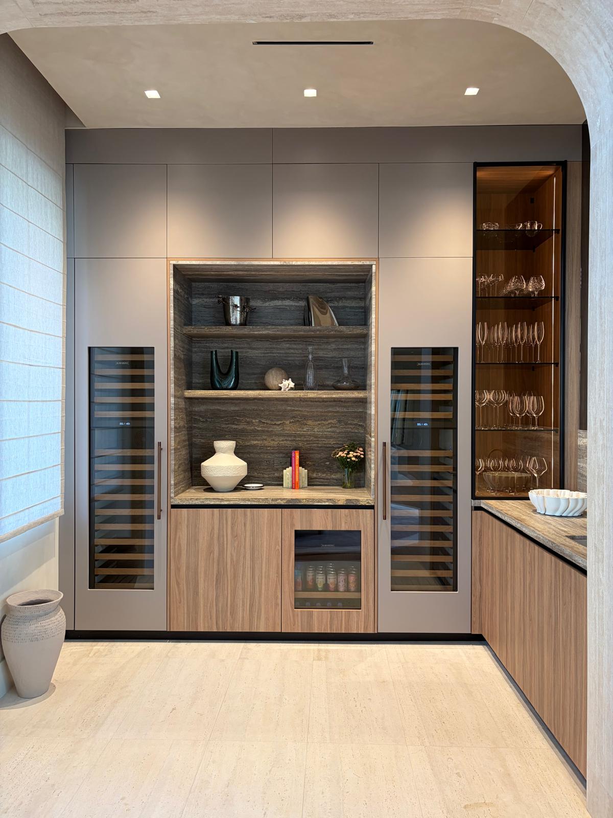 Built-in bar with wine fridges and backlit glass display cabinets