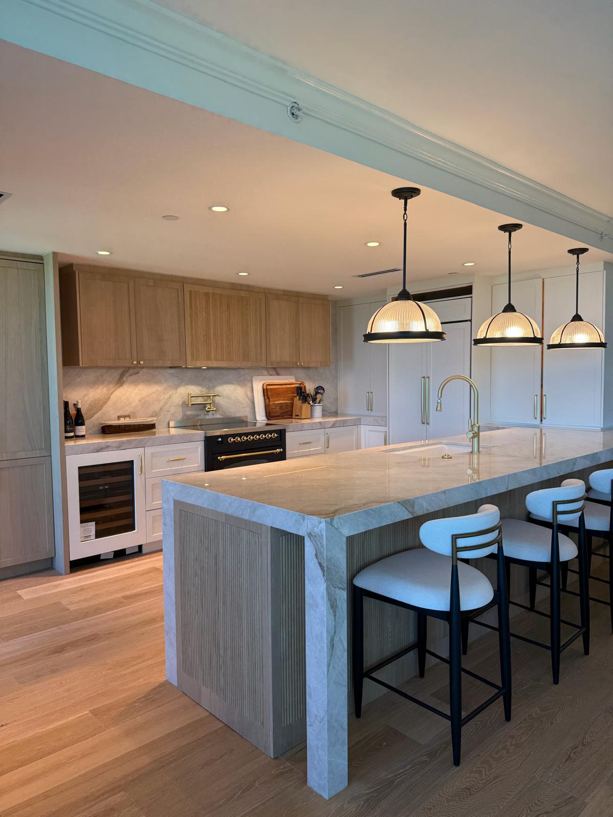 Kitchen with marble waterfall island and organized pantry shelving