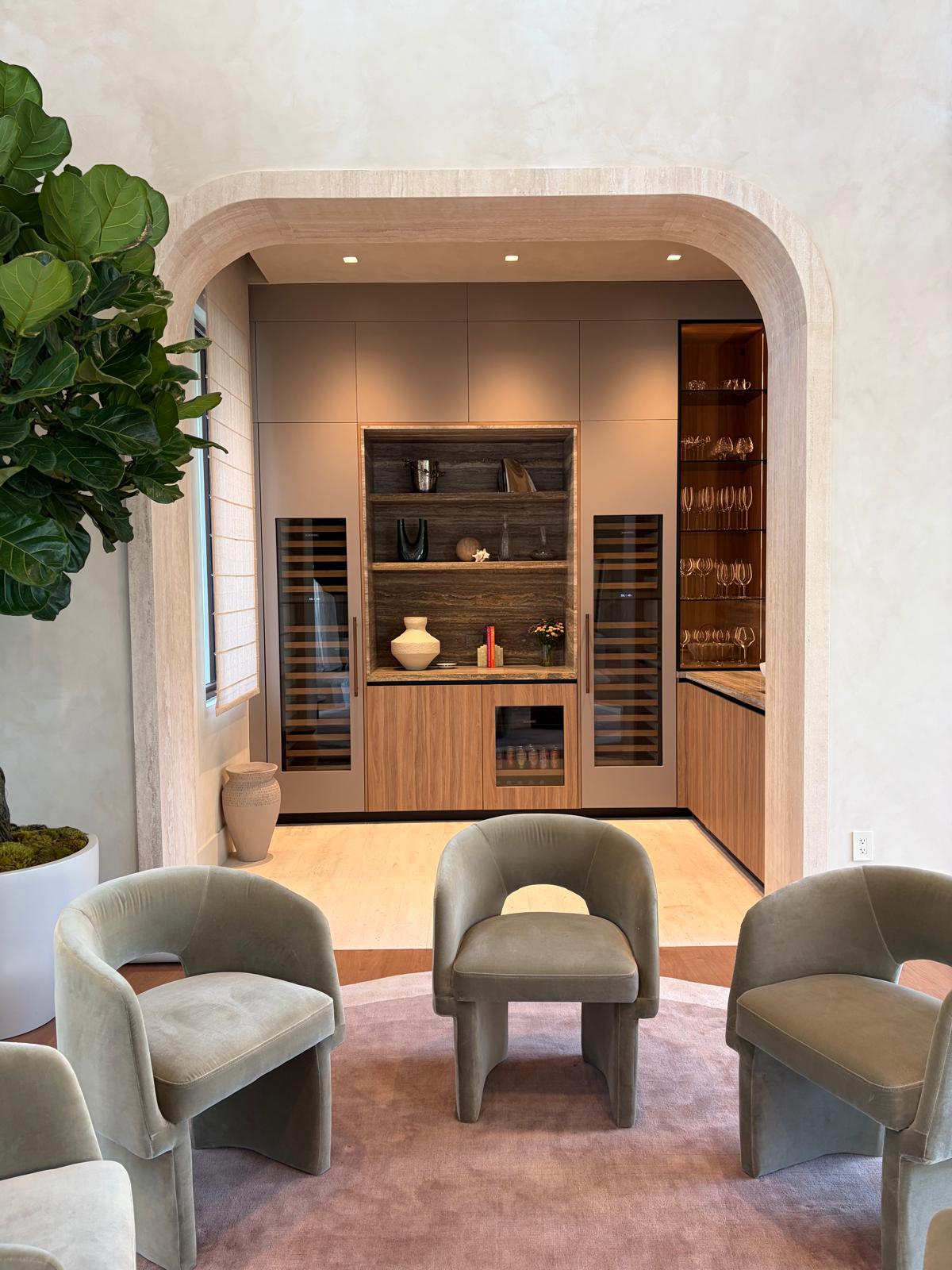 Lounge with leather club chairs framed by an arched entry